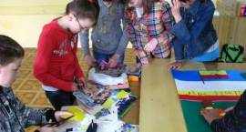 Uczniowie Szkoły Podstawowej w Kołakach Kościelnych wykonują plakat na konkurs, w...