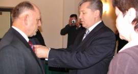 Wojewoda Podlaski Jan Dobrzyński przypina odznaki za zasługi na rzecz społeczności...